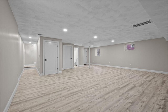 basement featuring visible vents, recessed lighting, light wood-style flooring, and baseboards
