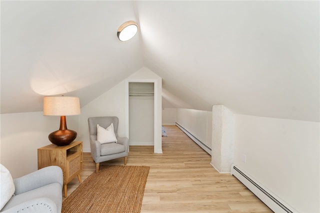 sitting room with light wood-style floors, a baseboard radiator, a baseboard heating unit, and lofted ceiling