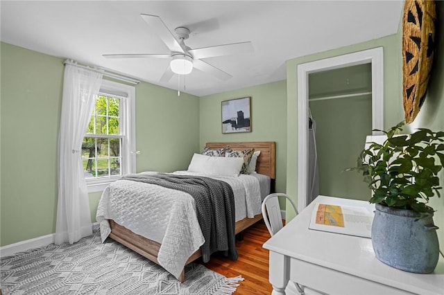 bedroom with baseboards, ceiling fan, and wood finished floors