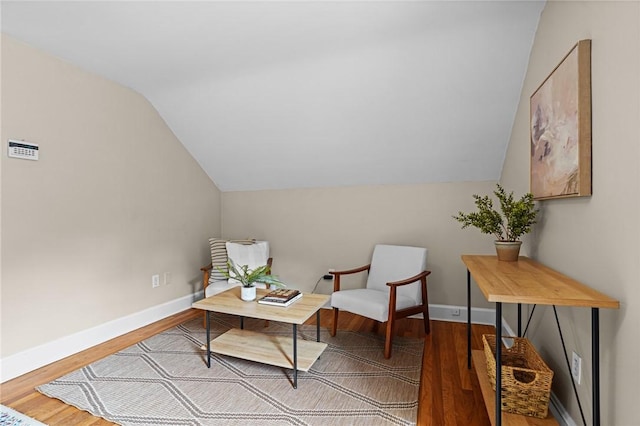sitting room with baseboards, vaulted ceiling, and wood finished floors