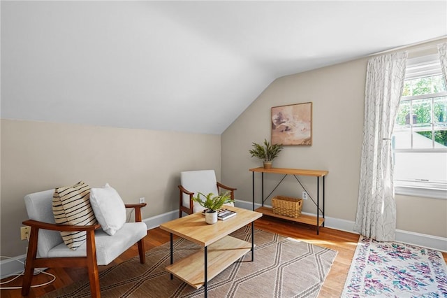 sitting room featuring baseboards, wood finished floors, and lofted ceiling