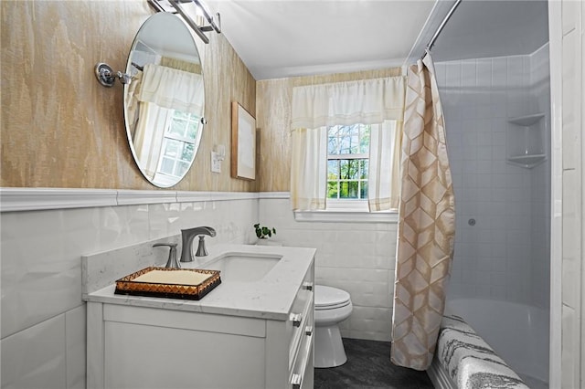 bathroom with vanity, shower / tub combo with curtain, toilet, and tile walls