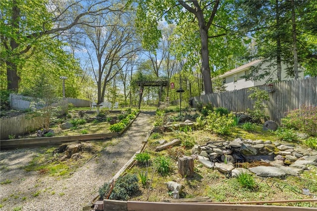 view of yard featuring fence and a vegetable garden