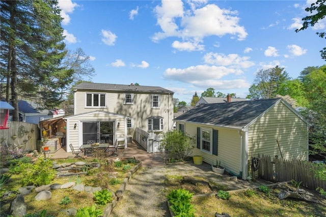 rear view of house with a patio area and fence