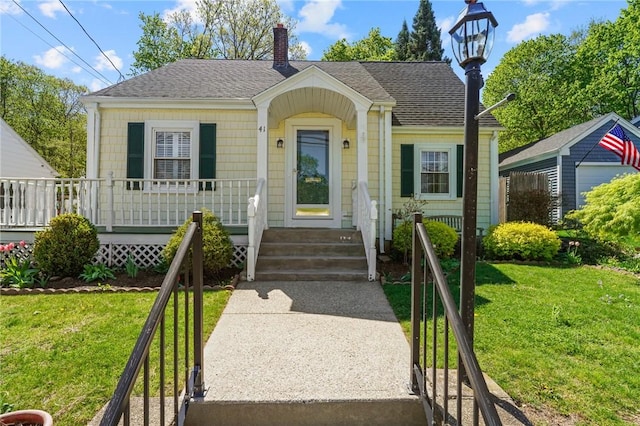bungalow-style house featuring a porch, a front lawn, roof with shingles, and a chimney