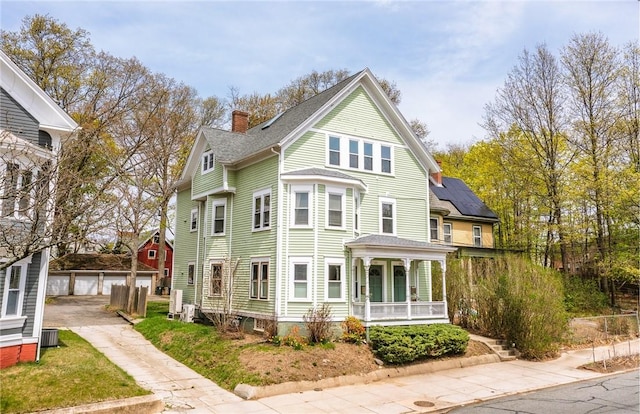 exterior space with an outdoor structure, a garage, covered porch, and a chimney