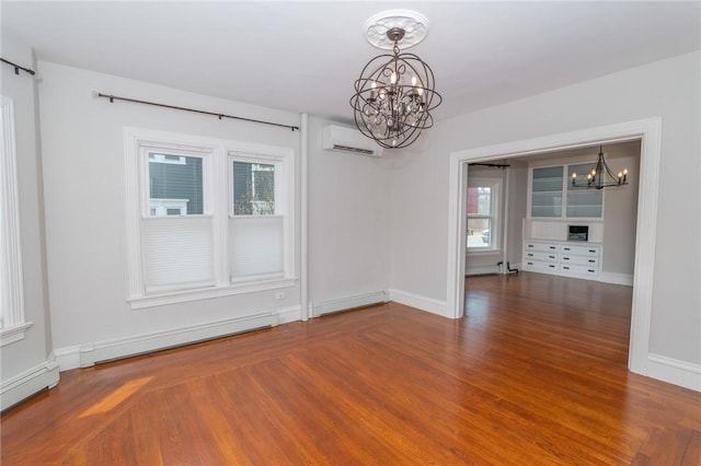 unfurnished dining area featuring wood finished floors, baseboards, baseboard heating, a wall mounted AC, and a chandelier