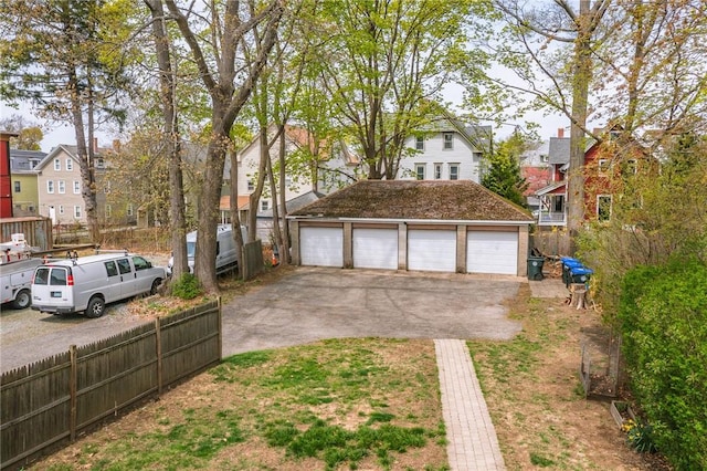 exterior space with an outdoor structure, a garage, fence, and a residential view