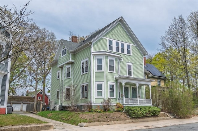 view of front of property featuring a porch, central air condition unit, and a chimney