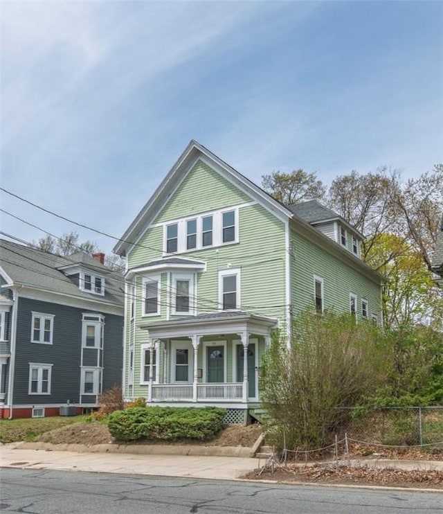 victorian house with covered porch and fence