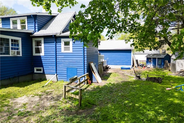 71 Centennial St, Burrillville, RI 02859 - back of property with a storage unit, a lawn, a shingled roof, and an outdoor structure