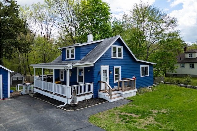71 Centennial St, Burrillville, RI 02859 - view of front of home with a storage unit, a front lawn, covered porch, an outdoor structure, and a chimney