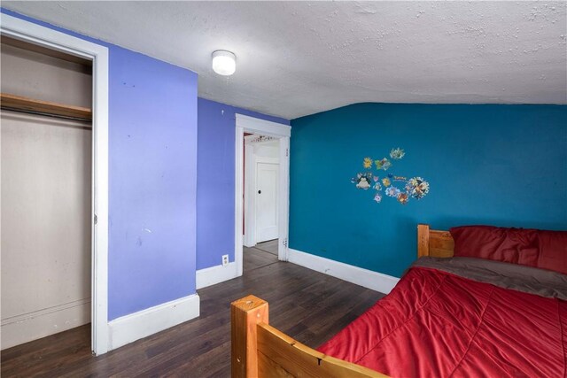 71 Centennial St, Burrillville, RI 02859 - bedroom with wood finished floors, a textured ceiling, baseboards, lofted ceiling, and a closet