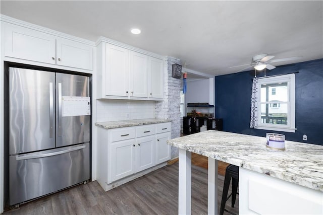 71 Centennial St, Burrillville, RI 02859 - kitchen with freestanding refrigerator, white cabinets, dark wood-type flooring, decorative backsplash, and a breakfast bar area