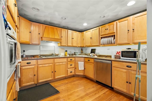 kitchen with white appliances, custom exhaust hood, light wood-style flooring, and light brown cabinets
