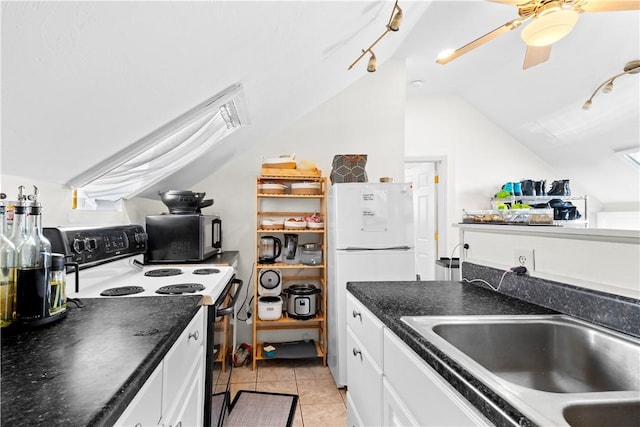 kitchen with range with electric cooktop, dark countertops, a sink, freestanding refrigerator, and lofted ceiling