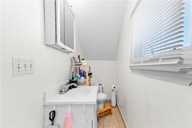 half bathroom with toilet, tile patterned floors, and vanity