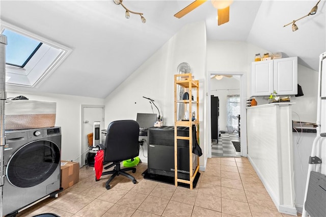 home office featuring ceiling fan, light tile patterned floors, track lighting, lofted ceiling with skylight, and washer / dryer
