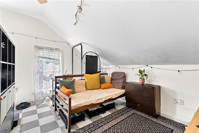 bedroom featuring baseboards, tile patterned floors, and lofted ceiling