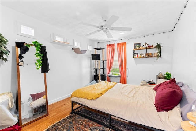 bedroom featuring baseboards, a ceiling fan, and wood finished floors
