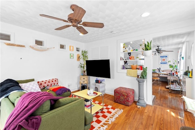 living room featuring wood-type flooring, recessed lighting, ceiling fan, and baseboards