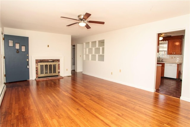 7 Smithfield Dr, Middletown, RI 02842 - unfurnished living room featuring a sink, a brick fireplace, wood finished floors, baseboards, and a ceiling fan