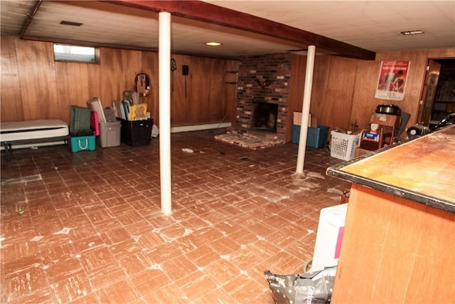 7 Smithfield Dr, Middletown, RI 02842 - basement featuring a baseboard heating unit, wood walls, brick patterned floor, and a fireplace