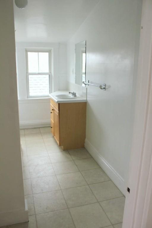 bathroom featuring vanity, baseboards, and tile patterned floors