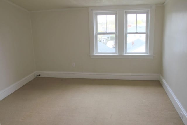 carpeted spare room with plenty of natural light and baseboards