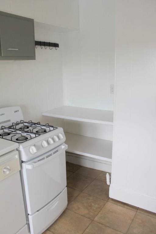 kitchen featuring light countertops, gray cabinets, white range with gas cooktop, and light tile patterned flooring