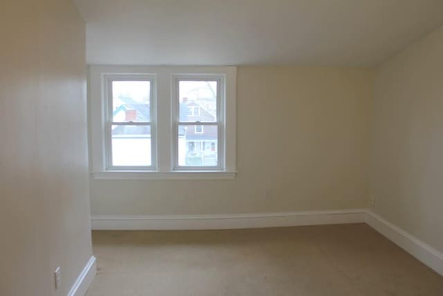 empty room with baseboards and light carpet