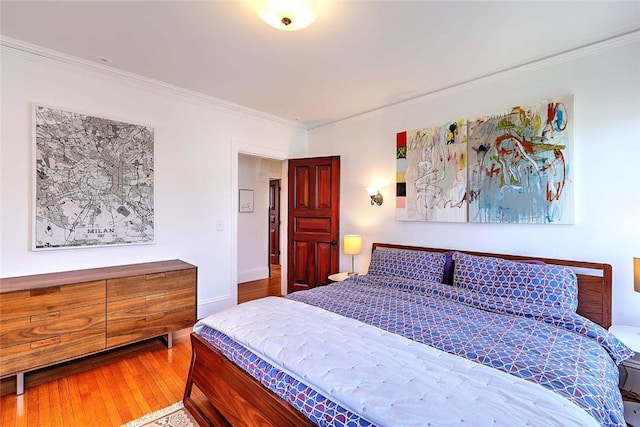 bedroom featuring ornamental molding and hardwood / wood-style floors