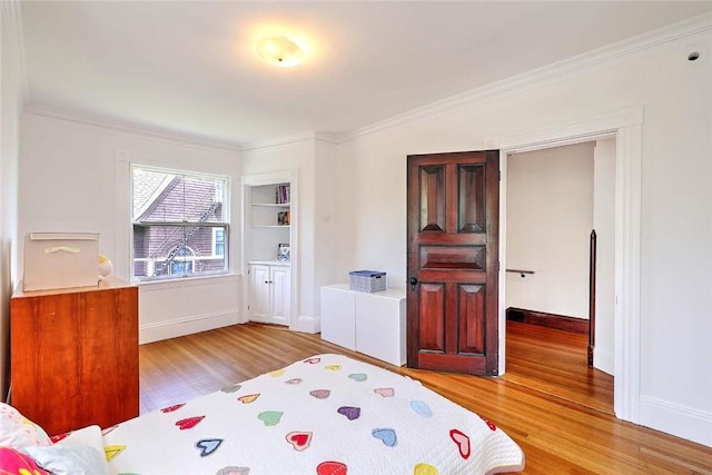 bedroom featuring light wood-style floors, baseboards, and crown molding