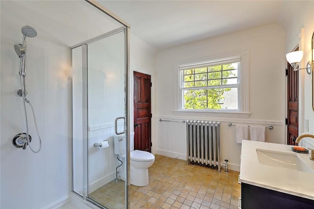 full bathroom with radiator heating unit, vanity, a wainscoted wall, and a shower stall