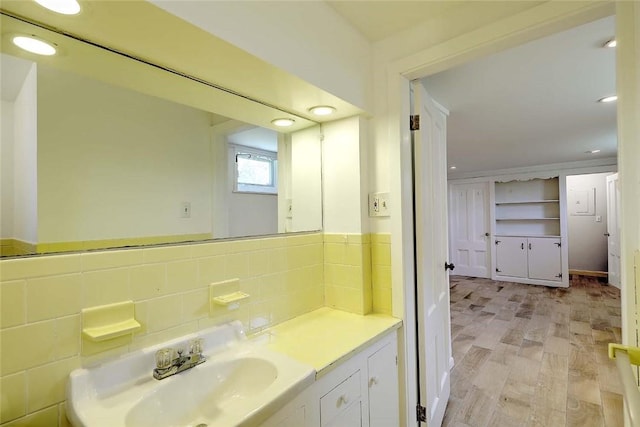 bathroom featuring recessed lighting, a sink, and decorative backsplash