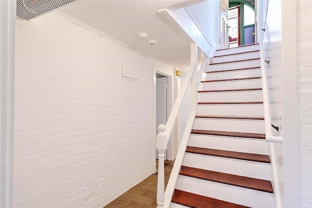 stairs with wood finished floors and visible vents