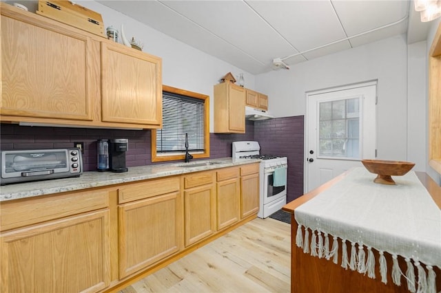 94 Cowesett Ave Unit 1, West Warwick, RI 02893 - kitchen with light brown cabinetry, a sink, white gas range oven, under cabinet range hood, and a wealth of natural light