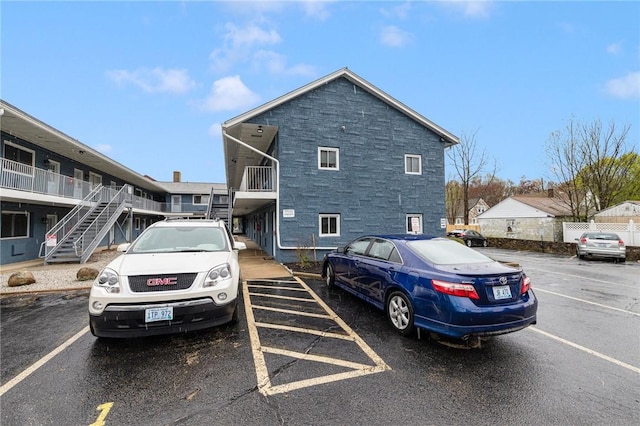 94 Cowesett Ave Unit 1, West Warwick, RI 02893 - view of home's exterior featuring stairs, uncovered parking, and stone siding