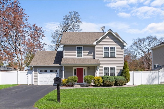 traditional-style house featuring fence, aphalt driveway, a front yard, and a garage