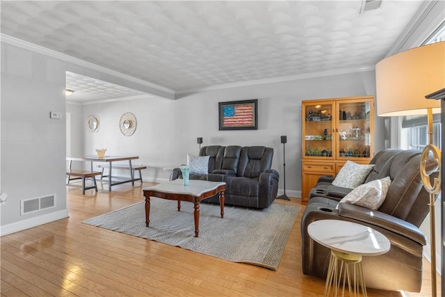 living area featuring baseboards, light wood finished floors, and visible vents