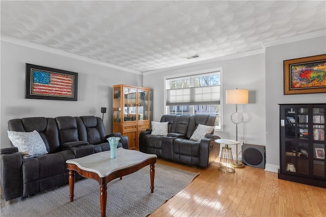 living area featuring baseboards, ornamental molding, hardwood / wood-style flooring, and visible vents