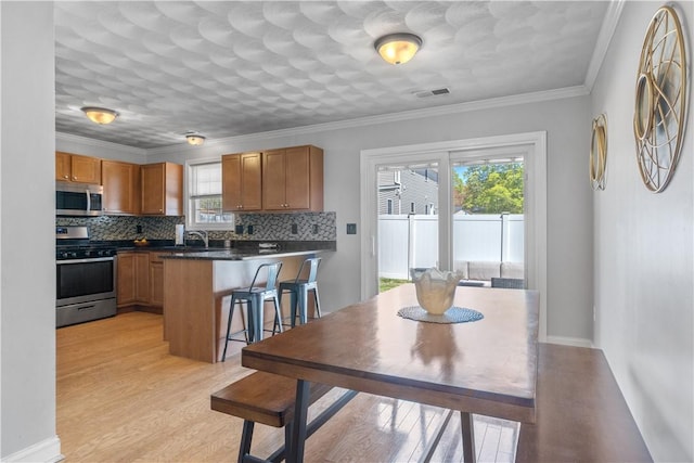 kitchen with visible vents, a peninsula, appliances with stainless steel finishes, and a healthy amount of sunlight