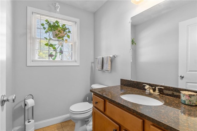bathroom with vanity, baseboards, tile patterned floors, and toilet