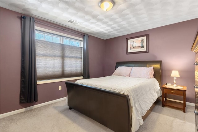bedroom with baseboards, visible vents, and light colored carpet