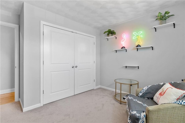 living area with baseboards and carpet flooring