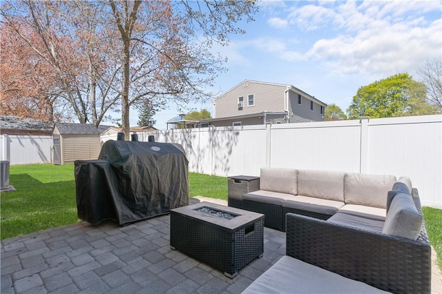 view of patio featuring an outdoor living space with a fire pit, a fenced backyard, area for grilling, a storage shed, and an outbuilding