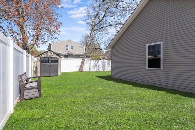 view of yard with a fenced backyard, a storage unit, and an outbuilding
