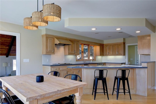 kitchen featuring custom range hood, light wood finished floors, a wealth of natural light, and tasteful backsplash