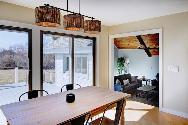 dining room with wooden ceiling, baseboards, plenty of natural light, and light wood-type flooring