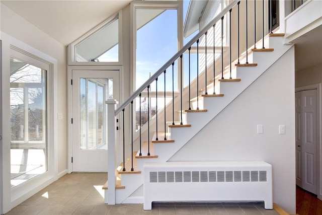 foyer with stairway, radiator, and baseboards